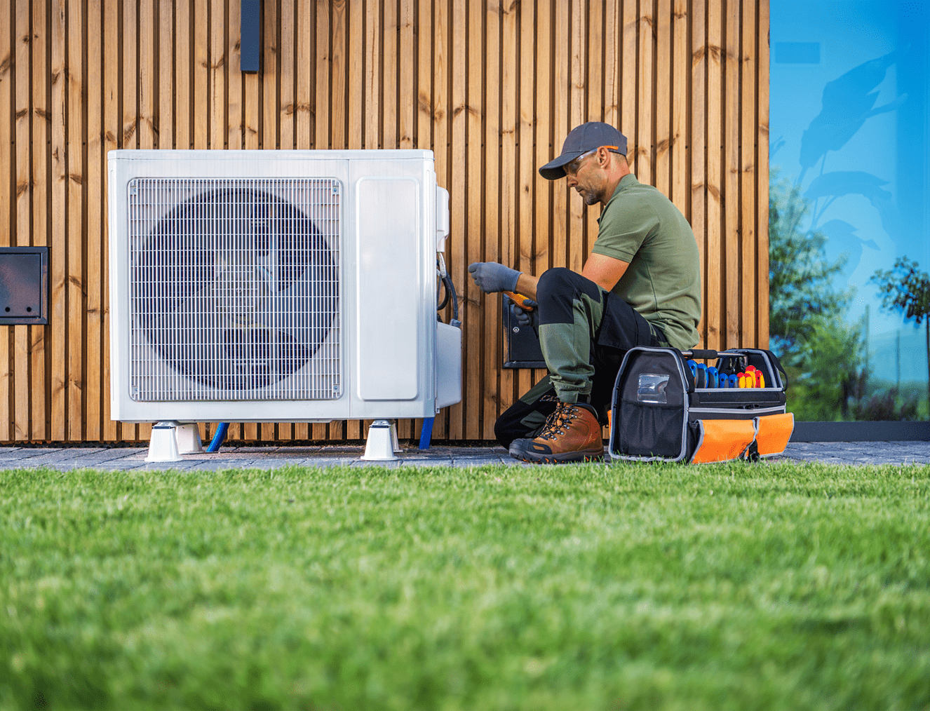 Maintenance worker fixing residential air conditioner