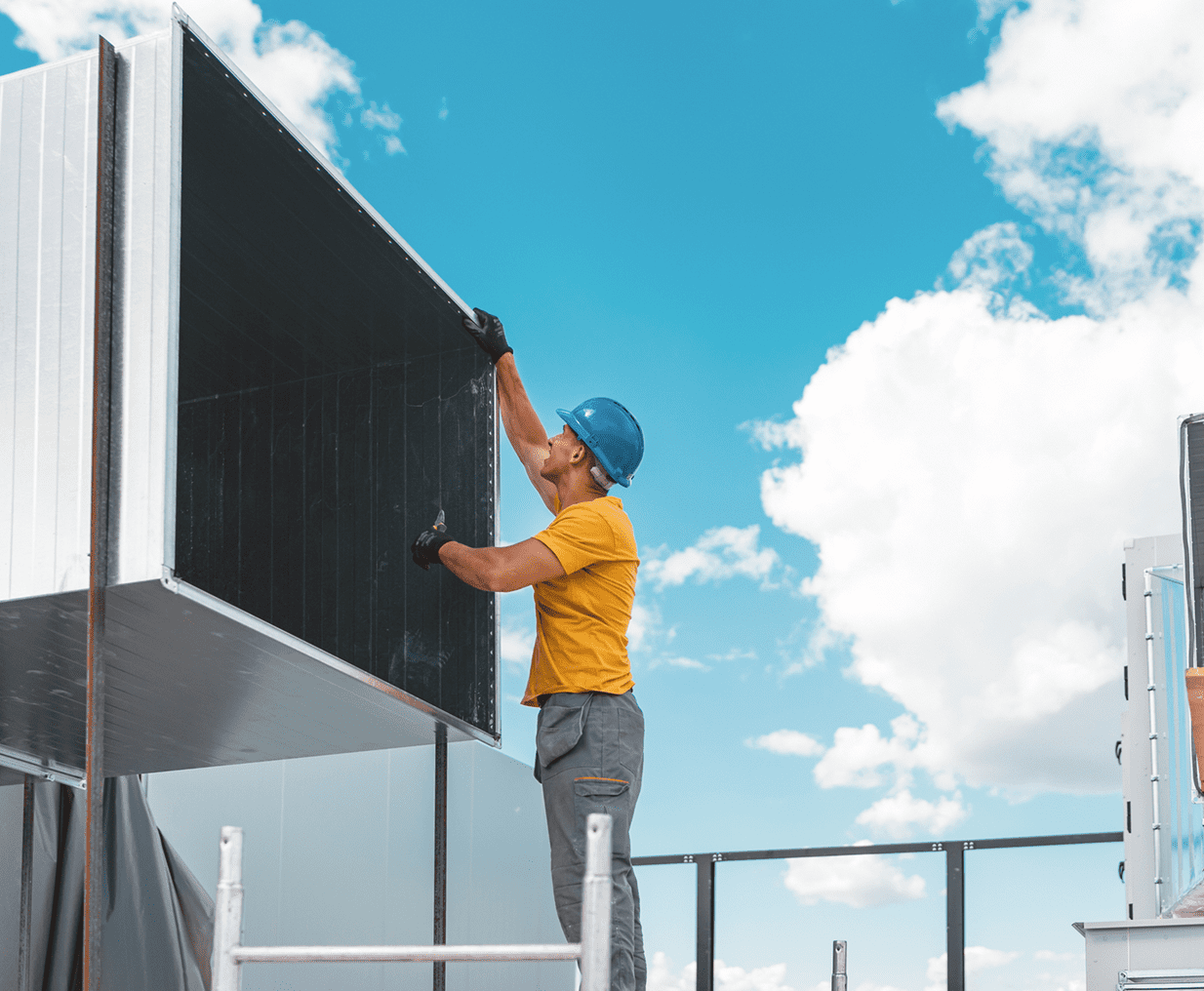 Construction worker assembling metal ductwork